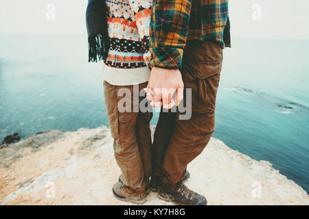 Giovane uomo e donna tenendo le mani in piedi sulla roccia a picco sul mare amore del paesaggio e viaggio felice emozioni concetto di stile di vita. Giovane famiglia in viaggio roma