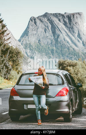 Giovane donna che viaggiano in auto a noleggio roadtrip con mappa in Norvegia viaggio concetto Lifestyle adventure week end vacanze outdoor Foto Stock