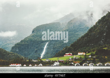 Montagne di nebbia e la cascata di paesaggio di villaggio in Norvegia paesaggio di viaggio Foto Stock