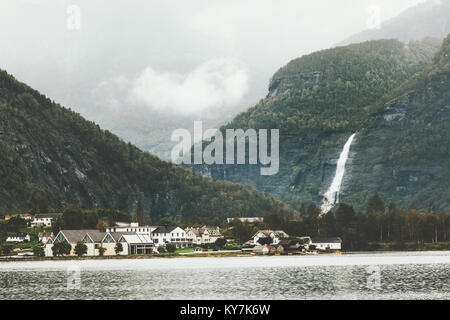 Montagne di nebbia e la cascata di paesaggio di villaggio in Norvegia paesaggio viaggio moody meteo Foto Stock