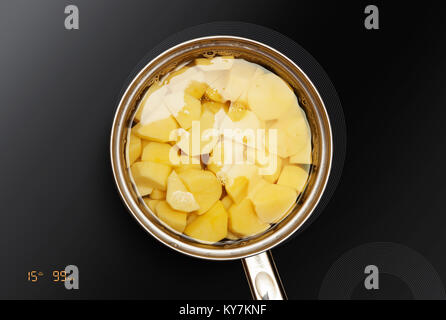 Panoramica sulla superficie di induzione in cui le patate è cotto Foto Stock