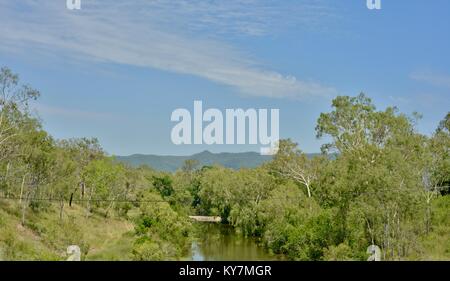 Un fiume che scorre attraverso la boccola, i terreni agricoli e bush vicino Clairview, Queensland, Australia Foto Stock