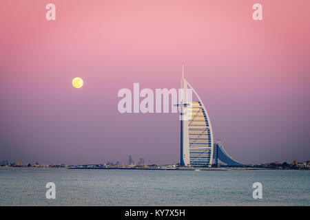Dubai, UAE, Dicembre 13, 2016: la luna piena è in aumento su Burj Al Arab - il mondo solo 7 stelle lusso Foto Stock