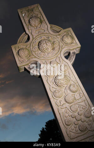 Un design celtica headstone situato nel cimitero di corstorphine vecchia chiesa parrocchiale insieme contro una violenta del cielo della sera Foto Stock