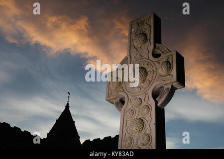 Un design celtica pietra tombale situato nel parco di corstorphine vecchia chiesa parrocchiale di Edimburgo insieme contro un cielo tempestoso Foto Stock