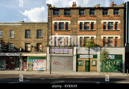 London, England, Regno Unito - 9 Luglio 2014: Scruffy negozi occupano malandato edifici sulla trafficata Old Kent Road nel sud est di Londra, un importante riqualificazione urbana Foto Stock