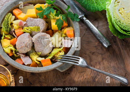 Irish spezzatino di maiale con patate e cavolo, carota, svedese e la pancetta cotta nel sidro - vista superiore Foto Stock