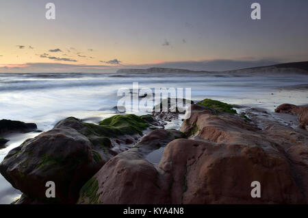 Una rilassante, atmosferici e splendidi paesaggi marini secondario di Compton Bay sulla costa sud occidentale dell'Isola di Wight. Rocce e alghe marine con onde. Foto Stock