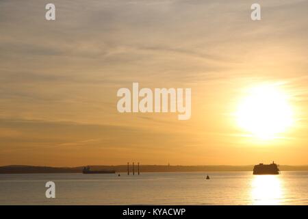 Bella autunno arancione tramonto sul dock di Portsmouth con la riflessione in acqua Foto Stock