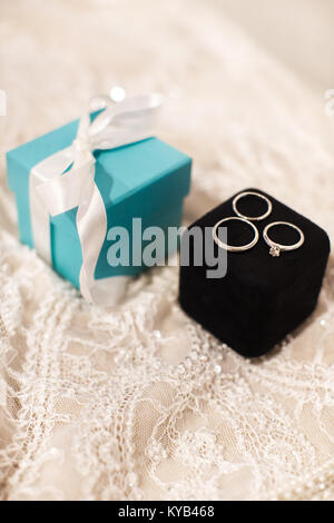 Gli anelli di nozze su una scatola di gioielli e una scatola di tiffany colore con un inchino Foto Stock