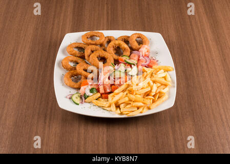 Calamari con verdure e patate fritte su sfondo bianco Foto Stock