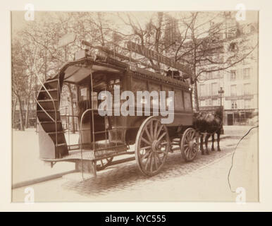 «Omnibus» di Eugène Atget (1910) è una fotografia in bianco e nero che raffigura la vita urbana nella Parigi dei primi anni del XX secolo. L'immagine documenta l'architettura parigina, i trasporti e le scene di strada quotidiane durante il periodo della Belle Époque. Foto Stock