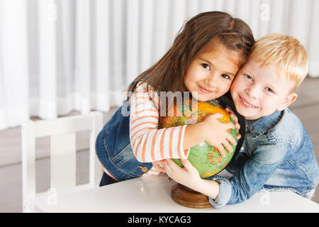 Bella 5 anni i bambini piccoli che abbraccia il mondo Foto Stock