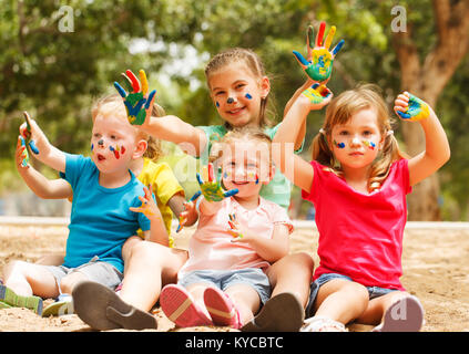 Cinque felici i bambini con mani coperte di vernice Foto Stock