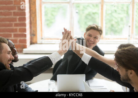 Happy business persone dando alta cinque all'incontro per celebrare il successo del progetto condiviso diversi dirigenti motivati unire le mani insieme, l'unità guida Foto Stock