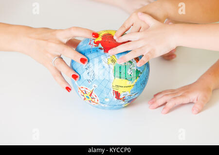 Multiculturale mani per bambini su un globo Foto Stock