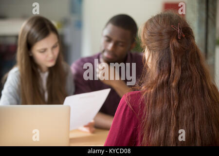 Vista posteriore a donna ricorrente durante il colloquio di lavoro concetto, diverse dal team HR lettura candidati riprendere, donna manager in attesa mentre i clienti i clienti c Foto Stock