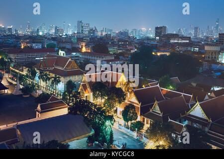Bangkok alla notte. Gli edifici di vecchia costruzione contro la parte moderna della città con grattacieli. Foto Stock
