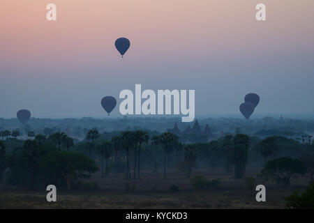 Silhouette di antichi templi e pagode e diverse mongolfiere sopra l antica pianura di Bagan in Myanmar (Birmania) all'alba. Copia dello spazio. Foto Stock