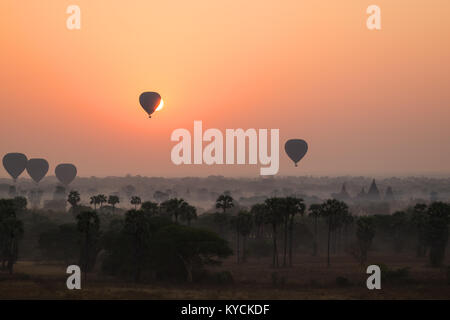 Silhouette di antichi templi e pagode e diverse mongolfiere sopra l antica pianura di Bagan in Myanmar (Birmania) all'alba. Copia dello spazio. Foto Stock