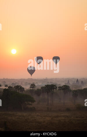 Silhouette di antichi templi e pagode e tre mongolfiere sopra l antica pianura di Bagan in Myanmar (Birmania) all'alba. Copia dello spazio. Foto Stock