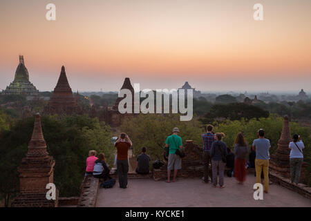 Vista panoramica di molti templi e manciata di turisti alla legge Ou Ka Shang Tempio aspettando il sorgere del sole in Bagan, Myanmar (Birmania), al mattino. Foto Stock