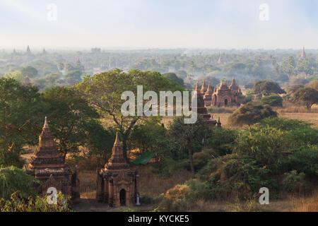 Vista panoramica di molti templi e pagode e altri edifici presso l'antica pianura di Bagan in Myanmar (Birmania), al mattino. Foto Stock