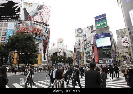 Una grande folla di persone attraversano un incrocio in un giorno di pioggia in Shibuya, un famoso distretto dei negozi e degli intrattenimenti in Tokyo, Giappone, con molti cartelloni visibile su edifici vicini, 13 ottobre 2017. () Foto Stock