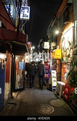 Salarymen in giacca a piedi attraverso il Golden Gai quartiere di Shinjuku a Tokyo, in Giappone, in un area nota per la sua vivace vita notturna e bar scena, Ottobre 24, 2017. () Foto Stock