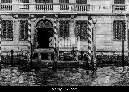 Venezia-MARZO 9:una barca di fronte all'ingresso principale di un antico edificio mentre una donna non identificato parla al telefono,Venezia,l'Italia,su marzo 9,2017. Foto Stock