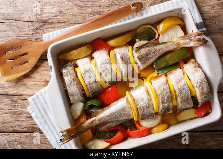 Merluzzo bianco cotto al forno con le verdure in una teglia close up su un tavolo. Parte superiore orizzontale vista da sopra Foto Stock