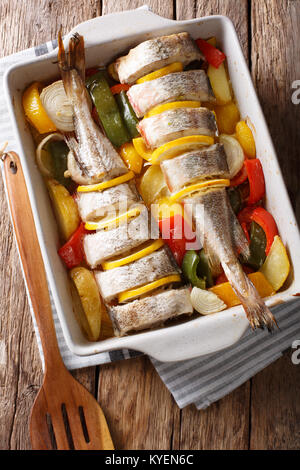 Merluzzo bianco cotto al forno con le verdure in una teglia close up su un tavolo. Verticale in alto vista da sopra Foto Stock