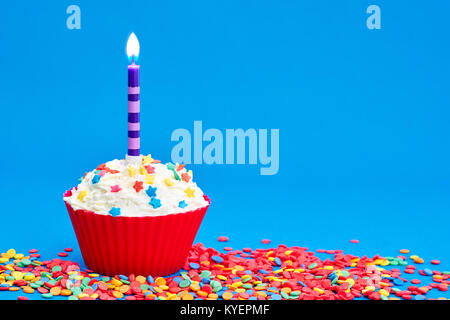 Tortina di compleanno con candele su sfondo blu Foto Stock