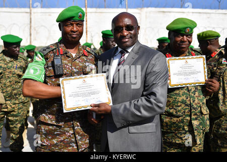 Questa immagine mostra Simon Mulongo, il rappresentante speciale aggiunto del presidente della Commissione dell'Unione africana (DSRCC) per la Somalia, che presenta un certificato a un ufficiale militare dell'AMISOM durante una cerimonia di premiazione della medaglia a Mogadiscio, Somalia, il 30 novembre 2017. Foto Stock
