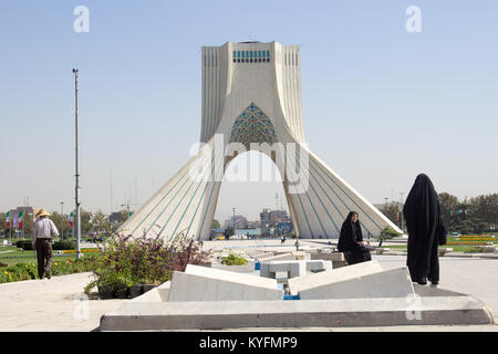 Immagine Torre Azadi nella capitale iraniana Teheran e due ragazze iraniane prendere foto souvenir di fronte al monumento. Foto Stock