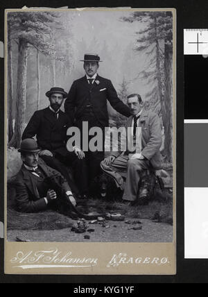 Un ritratto di quattro giovani uomini non identificati che visitano un fotografo, mostrando i loro vestiti, postura e disposizione di gruppo in una fotografia storica. Foto Stock