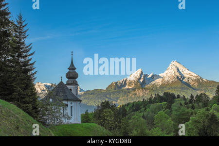 Mattina paesaggio panoramico con Maria Gern cappella e cime innevate del monte Watzmann bavarese nel parco nazionale di Berchtesgaden. Foto Stock