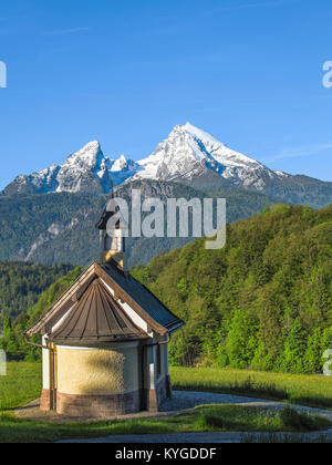 Vista verticale della piccola cappella e nevoso vetta del monte Watzmann bavarese nel parco nazionale di Berchtesgaden. Foto Stock