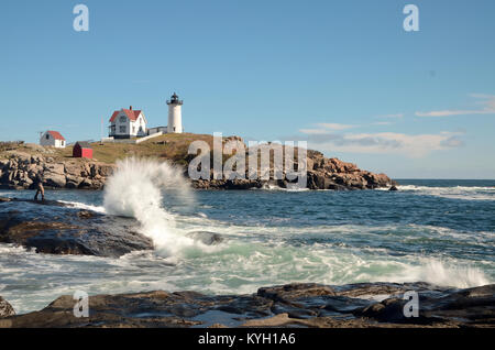 Onde si infrangono nella parte anteriore del faro Nubble, Cape Neddick Maine. Blue sky. Foto Stock
