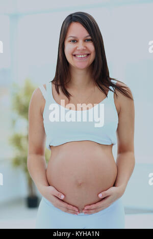 La donna trattiene il suo bambino bump. Foto Stock