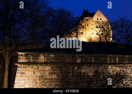 Il castello e le mura della città illuminata di notte in Nuermberg, Germania. Foto Stock