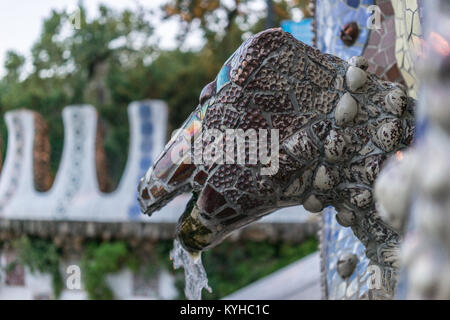 Mosaico e animale fontana scultorea dettagli in Park Gruell a Barcellona, Spagna. Architettura ornati, vista da sotto al tramonto, colori vibranti e Foto Stock