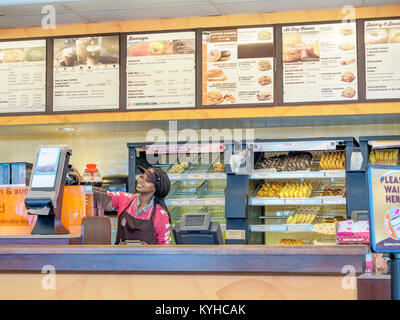 Femmina di afro-americano di fast food lavoratore presso il contatore di Dunkin Donuts in Montgomery, Alabama, Stati Uniti. Foto Stock