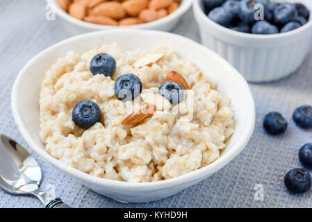 Porridge di fiocchi d'avena ciotola con mandorle e mirtilli. Primo piano Foto Stock