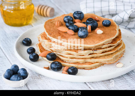 Senza glutine oat pancake con mirtilli e mandorle sulla piastra bianca. Primo piano Foto Stock