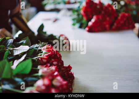 Fresh cut rose rosse giacciono sul tavolo Foto Stock