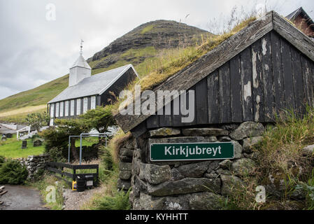 Barche a remi e tipica architettura in Kirkjubour sulle Isole Faerøer. Foto Stock