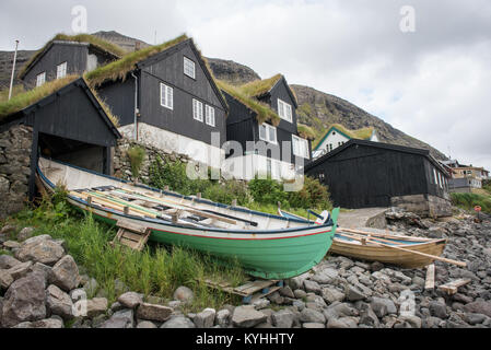 Barche a remi e tipica architettura in Kirkjubour sulle Isole Faerøer. Foto Stock