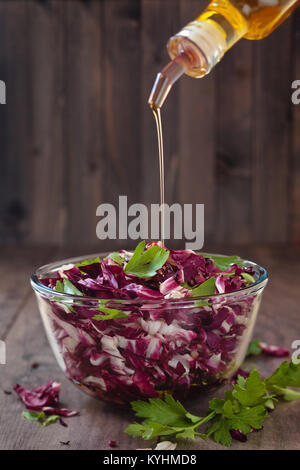 Shredded cavolo rosso in recipiente di vetro con prezzemolo e olio. Foto Stock