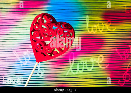 Forma di cuore contro colorato dipinto a mano sfondo colori misti Foto Stock